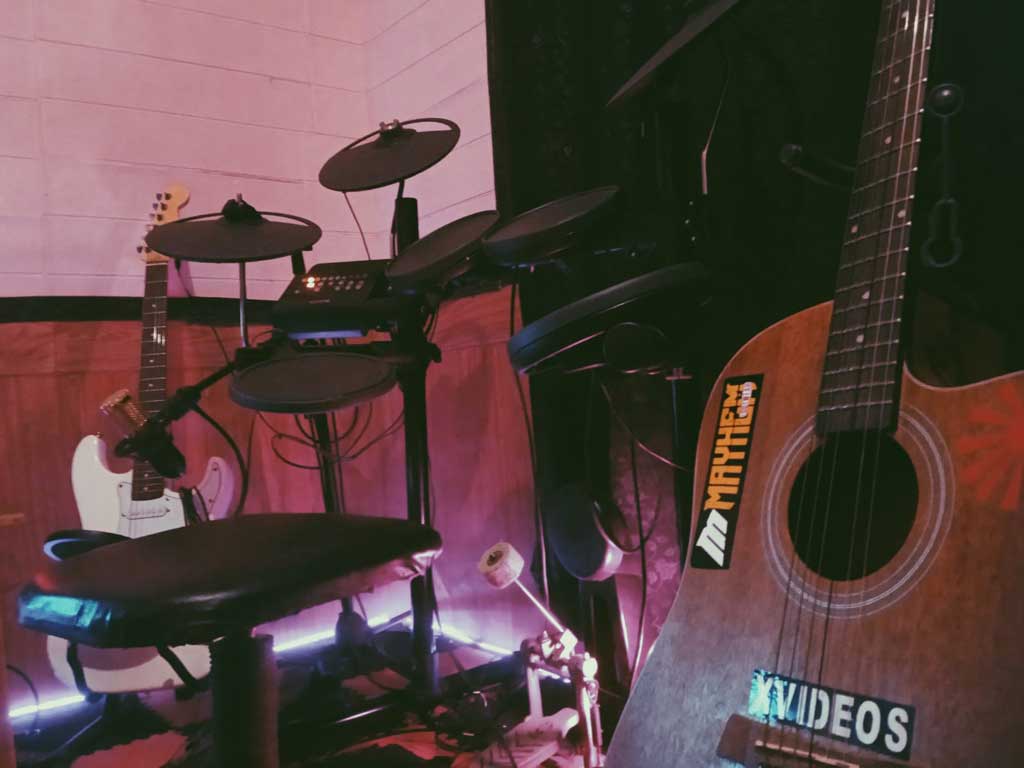 Gitar elektrik akustik dan drum studio rekaman.